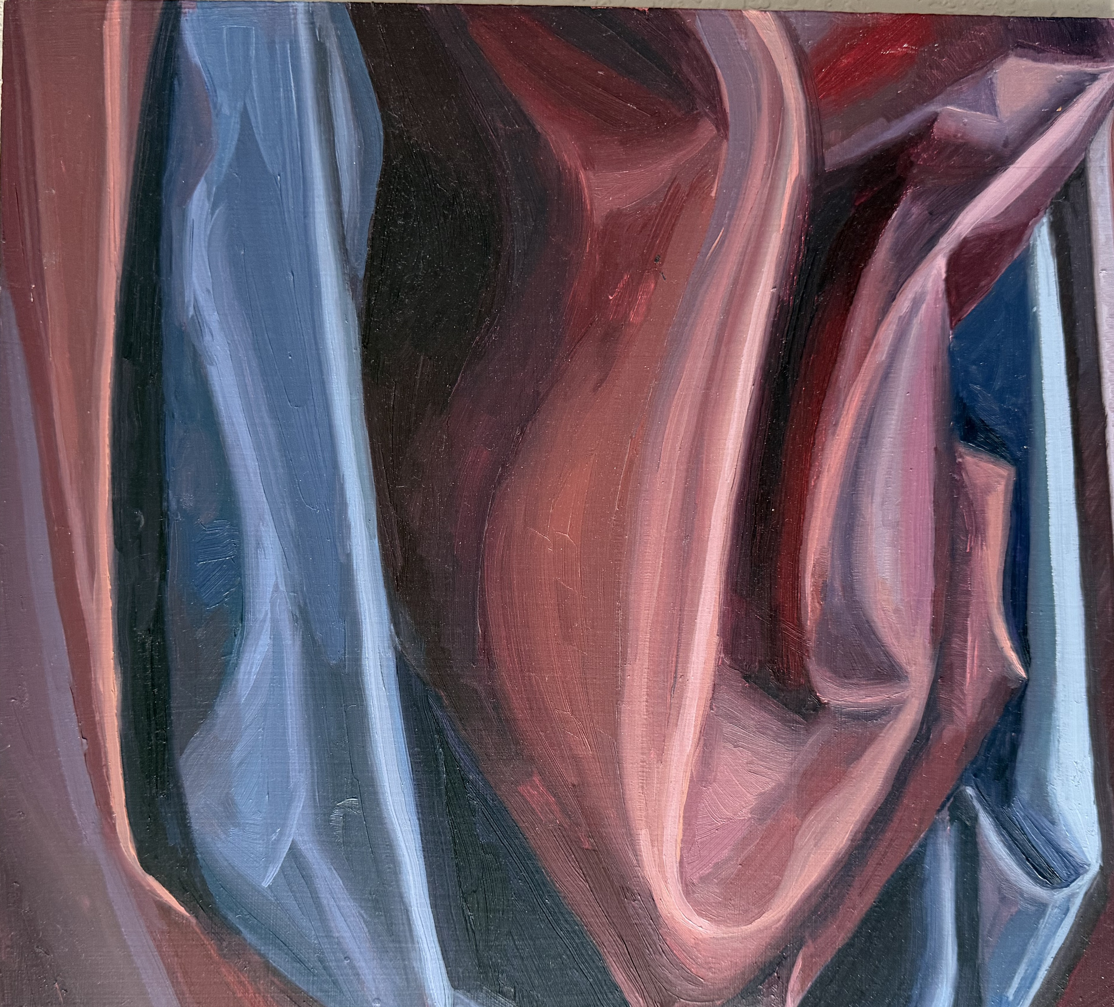 An oil study of folded fabric in deep crimson, rose, pink, and slate blue — heavy curling folds reading almost like a still life of stone.
